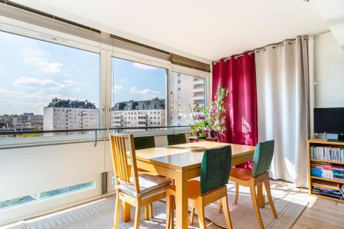 une salle à manger avec une table et des chaises et une grande fenêtre dans l'établissement GuestReady - Quaint and cute in the 15th arr, à Paris