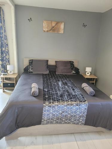 un grande letto in una camera da letto con due tavoli di Maison au bord du canal a Pagny-la-Ville