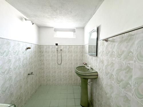 a bathroom with a green toilet and a sink at Shanti House in Weligama
