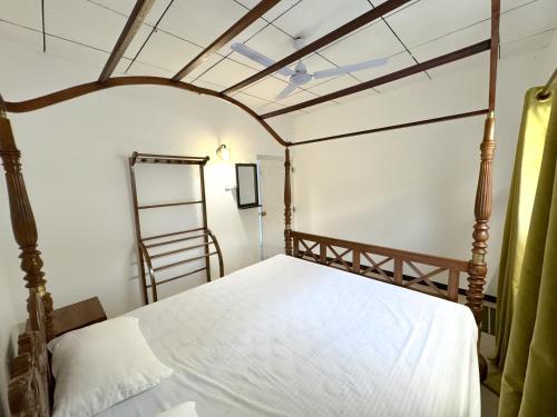 a bedroom with a bed with a ladder in it at Shanti House in Weligama