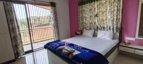 a small bedroom with a bed and a window at ShriHari Villa in Panchgani