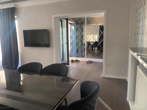 a living room with a glass table and chairs at Villa Mayak in Baku