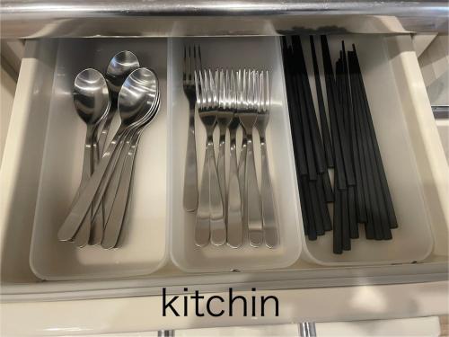 a drawer filled with silver utensils with the word kittin at Yellow House Okinawa in Naha