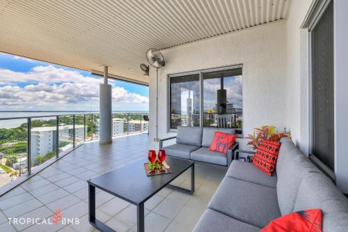 a living room with a couch and a table on a balcony at Penthouse Vibes Amazing Views From Top Floor in Darwin