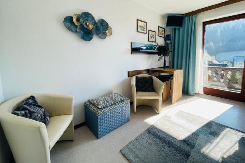 a living room with a couch and a chair and a window at Alpenpension Gasthof in Ratten