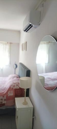 a bedroom with a bed and a mirror and a lamp at Departamento Centrico Tandil in Tandil