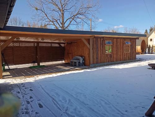 a large wooden building with a cover on a driveway at SZUMI LAS in Białowieża