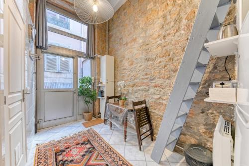 Cette chambre est dotée d'un mur en briques et d'une table. dans l'établissement GuestReady - Duplex Croix Rousse, à Lyon