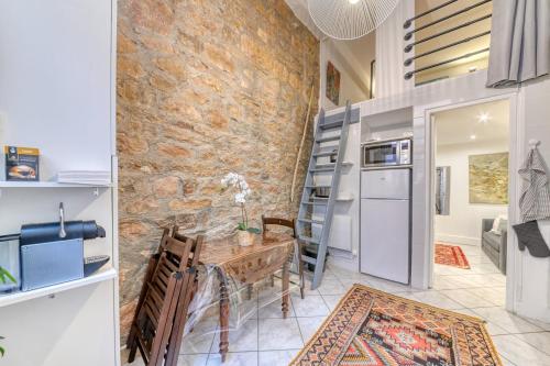 une cuisine et une salle à manger avec un mur en pierre dans l'établissement GuestReady - Duplex Croix Rousse, à Lyon