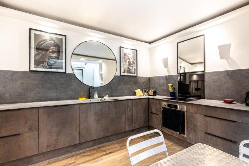 - une cuisine avec un évier et un miroir dans l'établissement GuestReady - Modern retreat near the Eiffel Tower, à Paris