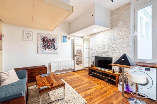 un salon avec un canapé et une télévision dans l'établissement GuestReady - Chic studio by Sacré-Cœur, à Paris