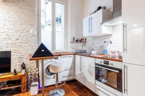 une cuisine avec des appareils électroménagers blancs et une fenêtre dans l'établissement GuestReady - Chic studio by Sacré-Cœur, à Paris