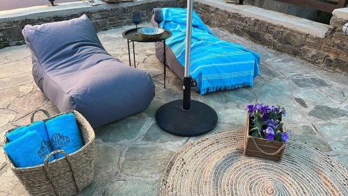 a patio with a couch and a table with flowers at Dandy Villas Tsagkarada - Blue Pansy - Mini Pool in Tsagarada