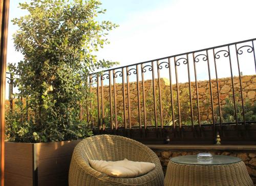 a rattan chair and a table on a balcony at Santa Lucia Boutique Hotel in Santa Luċija
