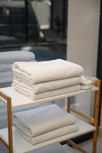 a stack of white towels on a shelf at Woodlander Mountain House Blidinje in Blidinje