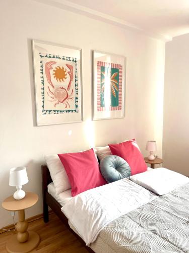 a bedroom with a bed with pink and blue pillows at Agapella Apartamemty- Villa Agapella 250m from the beach in Sopot