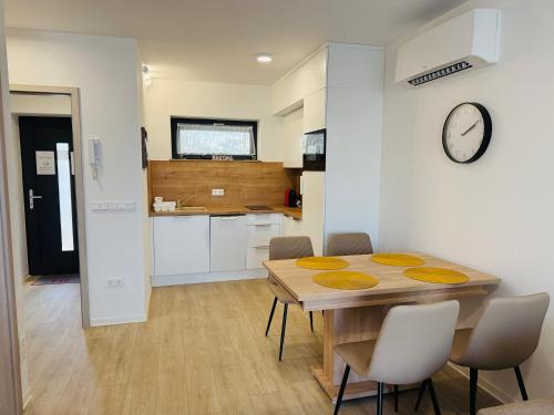 eine Küche und ein Esszimmer mit Tisch und Stühlen in der Unterkunft Casa Romana 3 Siófok apartman in Siófok