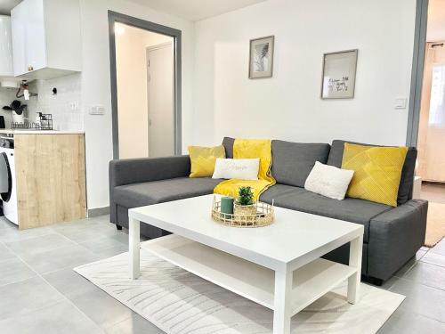 un salon avec un canapé et une table dans l'établissement L'Escale Express-2min Centre, 6min Aéroport, à Beauvais