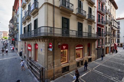 a group of people walking on a street in front of a building at Mercaderes 9 by Clabao in Pamplona