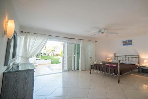 una camera da letto con un letto e una porta scorrevole in vetro di Spacious 3-bedroom beach Bungalow ad Adeje