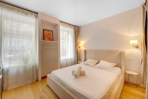 une chambre avec un lit blanc et une grande fenêtre dans l'établissement Hot district Faubourg Saint-Denis, à Paris