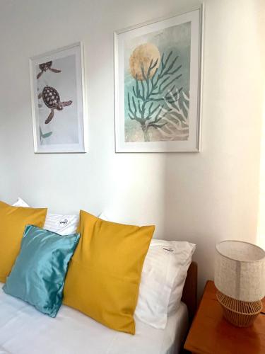 a bedroom with a bed with two pictures on the wall at Agapella Apartamemty- Villa Agapella 250m from the beach in Sopot
