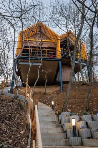 a building with a bed on top of some stairs at Erdei Szelencék in Sukoró