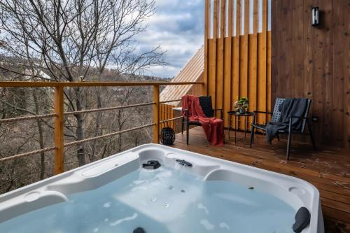 a bath tub on a deck with a table and chairs at Erdei Szelencék in Sukoró