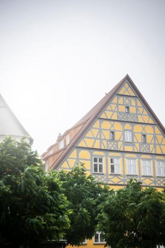 a half timbered building with trees in front of it at HOTEL & SPA Goldene Rose in Dinkelsbühl