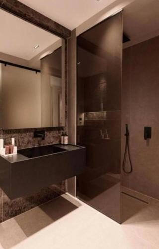 a bathroom with a black sink and a shower at Hotel Miramare in Vlorë