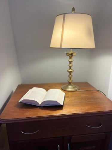 a lamp and an open book on a wooden table with a lamp gmaxwell gmaxwell gmaxwell at Agapella Apartamemty- Villa Agapella 250m from the beach in Sopot