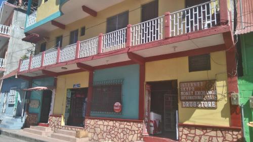 a building with a balcony on top of it at Hotel Posada Tayazal in Flores