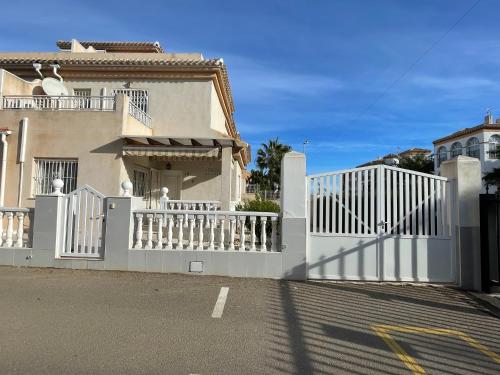 a white fence in front of a house at Villa Jacqueline la buena vida in Playa Flamenca