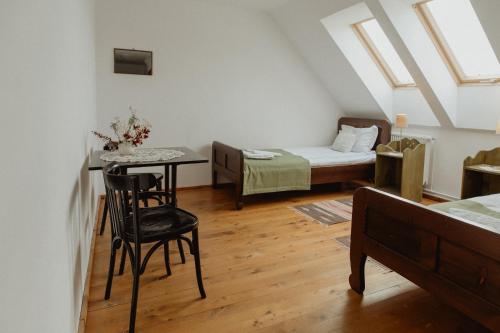 a small room with a bed and a table with a chair at Vass Panzio in Zălan