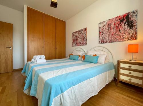 a bedroom with a large bed with blue sheets at Apartamentos da Orada T1-F124 Marina de Albufeira in Páteo