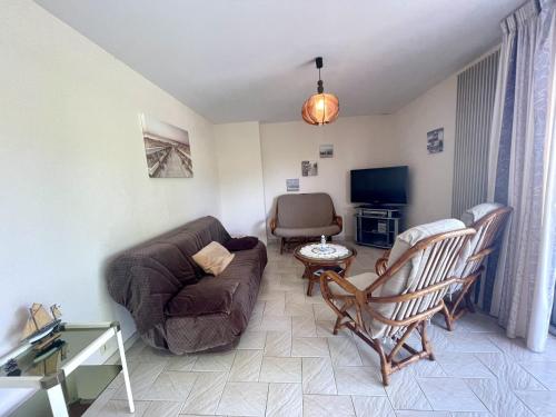 un salon avec un canapé et une chaise dans l'établissement Appartement 6 pers face au Jaunay, à Saint-Gilles-Croix-de-Vie