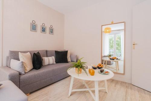 a living room with a couch and a table at Les Capitouls - avec entrée autonome, clim neuve, jardin, parking privé & sa piscine ! - in Toulouse