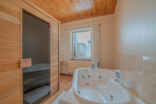 a bathroom with a bath tub and a sink at Hotel Hotleu in Waimes