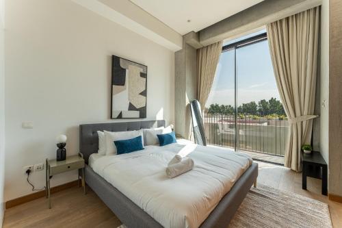 a bedroom with a large bed with a large window at HAVN - 1 Bed at KOA Canvas, Access to Nasab Dubai in Dubai