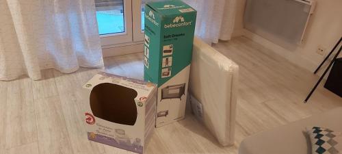 a cardboard box sitting on the floor in a room at Les Capitouls - avec entrée autonome, clim neuve, jardin, parking privé & sa piscine ! - in Toulouse