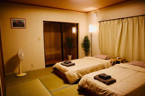 Postel nebo postele na pokoji v ubytování 桜の山荘