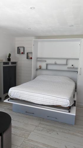 Ce lit se trouve dans une chambre dotée d'un cadre de lit blanc. dans l'établissement La Palombe, à Saint-Macaire