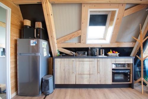 - une cuisine dans une petite maison avec un réfrigérateur dans l'établissement Le Tipi Bleu TINY HOUSE neuve avec terrasse et jardin, à Camaret-sur-Mer
