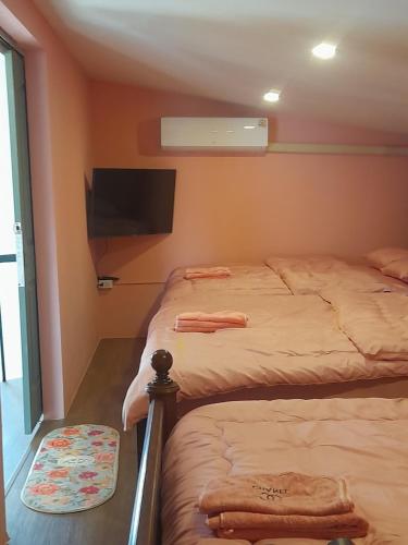 a bedroom with two beds and a flat screen tv at Paris De Floor Khaoyai in Pak Chong