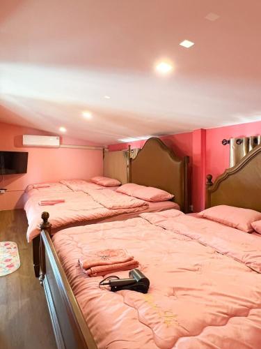 two beds in a room with pink walls at Paris De Floor Khaoyai in Pak Chong