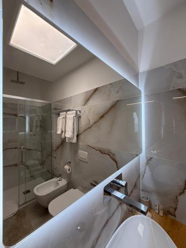 a white bathroom with a sink and a toilet at Bonocore Accomodation in Tropea