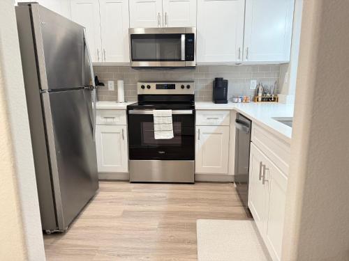 a kitchen with stainless steel appliances and white cabinets at Zen Oasis in Phoenix
