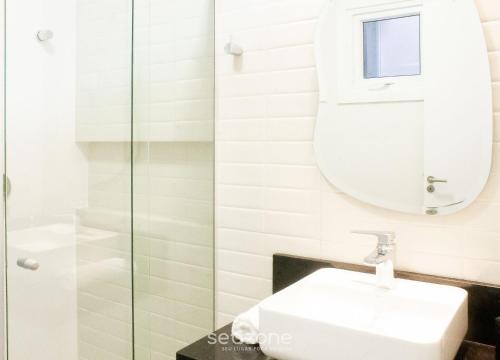 a bathroom with a sink and a mirror at Modern apartment with barbecue CRR201 in Florianópolis