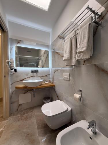 a bathroom with a white toilet and a sink at Bonocore Accomodation in Tropea