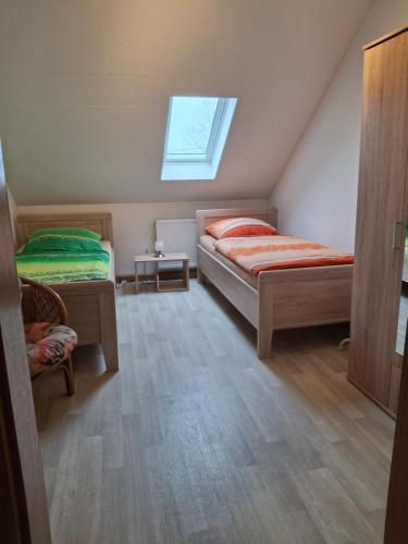 a attic bedroom with two beds and a window at Ferienwohnung Am Orlbach in Schönstedt
